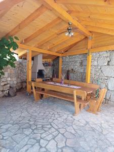 a wooden picnic table sitting under a wooden roof at Apartmani Afrodita in Crikvenica