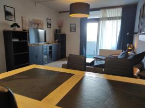 een woonkamer met een tafel, een bank en een tv bij Ferienwohnung Harzverliebt in Bad Harzburg