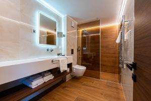 a bathroom with a sink and a toilet and a shower at Hotel De‘Andros Virpazar in Virpazar