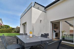 a gray table with chairs and a bottle on it at La Villa des Marettes - Piscine partagée in Pléneuf-Val-André