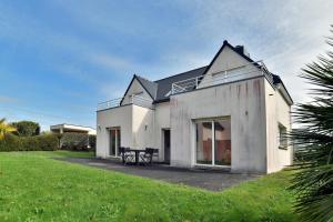 a white house with a table on a lawn at La Villa des Marettes - Piscine partagée in Pléneuf-Val-André
