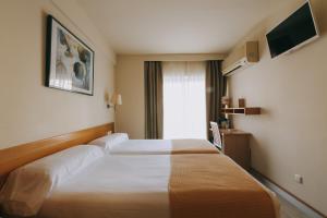 a hotel room with a large bed and a window at Hotel Zaragoza Plaza in Donostia-San Sebastián