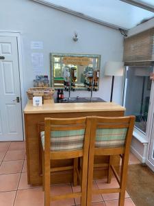 a kitchen with a counter with two chairs and a mirror at The Old Coach House in Blackpool