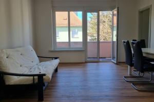 a living room with a couch and a table and windows at Charming flat in a quiet central location in Graz