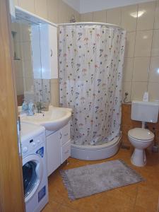 a bathroom with a toilet sink and a shower curtain at Apartmani Afrodita in Crikvenica