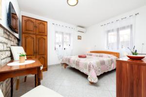 a bedroom with a bed and a dresser and a table at Apartments and Room Silvana in Rovinj