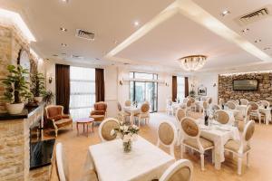 Habitación con mesas, sillas y pared de piedra. en Golden Hotel, en Pristina