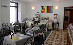 a dining room with tables and chairs in a restaurant at Hotel Italia in Turin