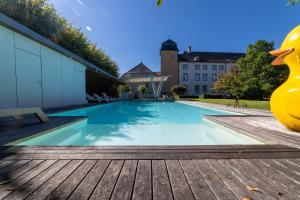 a swimming pool with a rubber duck sitting on a wooden deck at Château de Berg in Berg-sur-Moselle