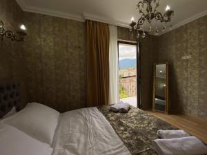 Un dormitorio con una cama grande y una ventana en Sunny City en Borjomi