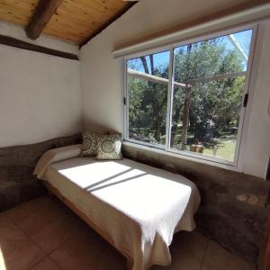 a bed in a room with a window at Complejo Cerro Norte in Piedras Blancas