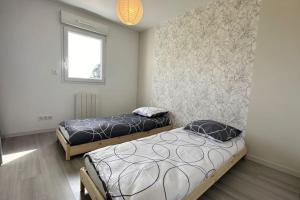 1 dormitorio con 2 camas y ventana en Cosy Nature, en Sainte-Pience