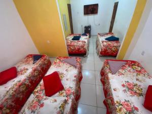 - 3 lits dans une chambre avec des oreillers rouges dans l'établissement Santa clara palace hotel, à Belém