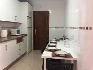 a kitchen with white cabinets and a counter with plates on it at Resplandeciente Apto Cerca de la Playa en Isla Cristina by Batuecas in Isla Cristina +12 photos