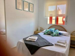 een slaapkamer met een bed met twee handdoeken erop bij Resplandeciente Apto Cerca de la Playa en Isla Cristina by Batuecas in Isla Cristina