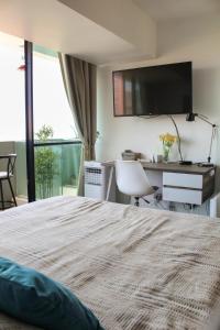 Habitación de hotel con cama, escritorio y TV. en Depto Estudio con Vista al Mar y Estacionamiento Servicio HOM 1016 en Antofagasta