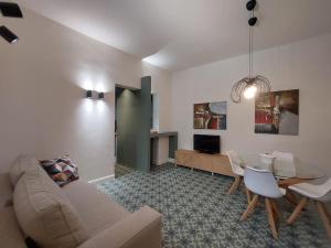 ein Wohnzimmer mit einem Sofa und einem Tisch in der Unterkunft Green Apartment - City Centre in Genua