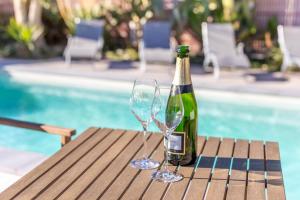 Villelongue-de-la-SalanqueにあるNotre cocon mer et montagneのワイン1本、テーブルに座ったグラス2杯