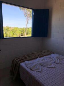 Cama en habitación con ventana grande en Villa Coral azul en Prado