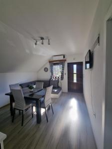 a dining room and living room with a table and chairs at Apartment Rosandić in Smoljanac