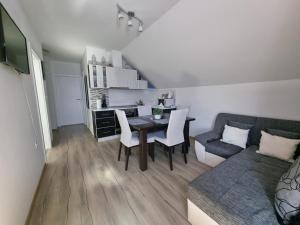 a living room with a table and a couch at Apartment Rosandić in Smoljanac