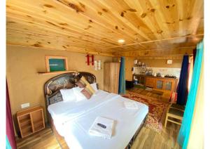 ein Schlafzimmer mit einem weißen Bett in einem Haus in der Unterkunft Zingo 1BHK Mudhouse in Manali