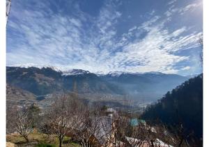 a view of a mountain range with snow covered mountains at Zingo 1BHK Mudhouse in Manāli