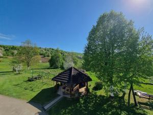 a small gazebo in a field with a tree at Apartment Rosandić in Smoljanac