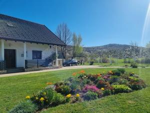 a garden in front of a house with flowers at Apartment Rosandić in Smoljanac