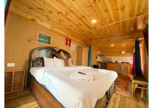 a bedroom with a large bed in a house at Zingo 1BHK Mudhouse in Manāli