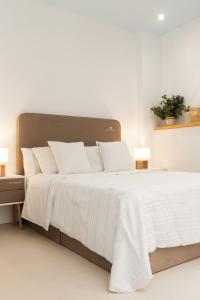 1 dormitorio con 1 cama blanca con sábanas y almohadas blancas en Apartamento Don Algodón Grau, en Los Mártires