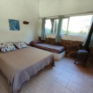 a bedroom with a bed and a couch and windows at Complejo Cerro Norte in Piedras Blancas