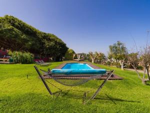 a swimming pool in a grassy yard with a swing at Villa with Pool and sea views in Banana Plantation in Arucas