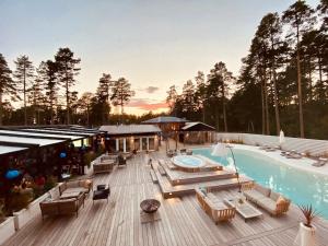 una terraza con piscina y sillas y un edificio en Hölick Havsresort & spa en Hudiksvall