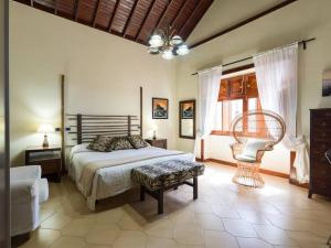 a bedroom with a bed and a chair and a window at Villa with Pool and sea views in Banana Plantation in Arucas