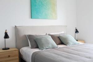a bedroom with a bed with two lamps and a painting at HOM I Amplio Depto 2D2B Estacionamiento y Terraza Vista al Mar PNM 1118 in Antofagasta