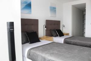 a hotel room with two beds and a television at HOM I Amplio Depto 2D2B Estacionamiento y Terraza Vista al Mar PNM 1118 in Antofagasta