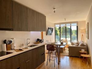 a kitchen with wooden cabinets and a table and a couch at Depto TOP1 con Estacionamiento en Puerto Varas in Puerto Varas