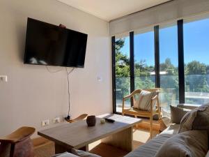a living room with a flat screen tv on the wall at Depto TOP1 con Estacionamiento en Puerto Varas in Puerto Varas