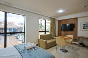 Un dormitorio con una cama, una mesa y un televisor. en Alugueasy - Hotel Athos Bulcão, en Brasilia