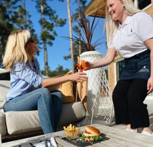 two women sitting on a couch holding a drink at Hölick Havsresort & spa in Hudiksvall