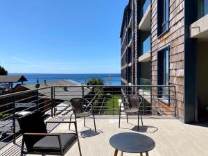 a balcony with chairs and a view of the ocean at Comodo Depto, en Puerto Varas Gran Terraza y Parking Servicio HOM in Puerto Varas