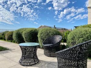 Dos sillas negras y una mesa en un patio. en HOM I Amplio Loft con Jardín en MejorLugar de Valparaíso 1109, en Valparaíso