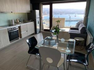 uma cozinha e sala de estar com mesa e cadeiras em Lujoso Estudio con Mejor Vista del Puerto Parking Servicio HOM 0408 em Valparaíso