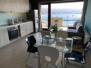 a kitchen and living room with a table and chairs at HOM I Lujoso Estudio con Mejor Vista del Puerto Parking 0408 in Valparaíso
