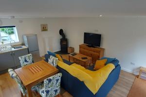 a living room with a blue couch and a table at Pond Puddle at Pond Pool Cottage in Taunton