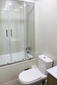 a white bathroom with a shower and a toilet at Espectacular Depto 1D1B, y Estacionamiento Privado Servicio HOM in Antofagasta