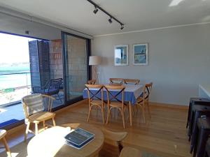 a dining room with a table and chairs and a large window at Depto 3D2B con 02Parking y Terraza en Puerto Varas Servicio HOM in Puerto Varas