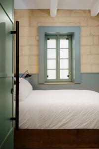 a bedroom with a bed and a window at Felipe x Casa Norte in Birgu