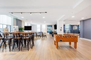 um escritório com uma mesa de pingue-pongue e uma sala de jantar em 2BR Luxury Apartment With Rooftop Deck & Pool em Baltimore